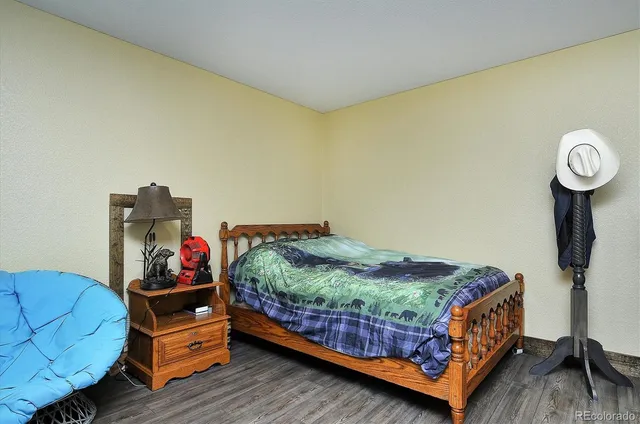 a bedroom with a bed and a wooden floor