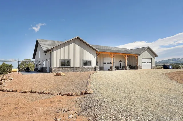 a front view of a house with a yard covered with snow in front of it