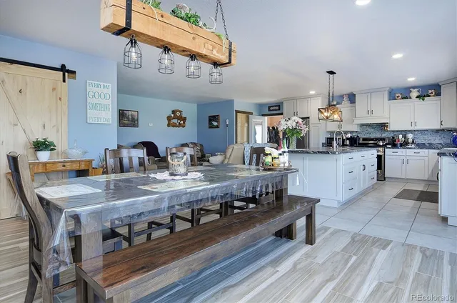 a dining room with furniture a chandelier and wooden floor
