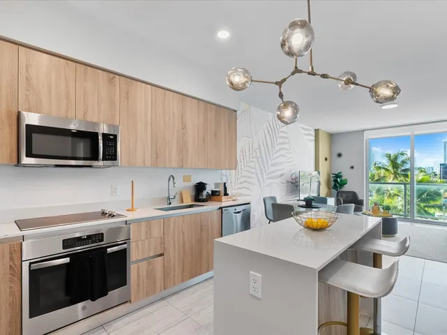 a kitchen with stainless steel appliances a stove a microwave a dining table and chairs in it