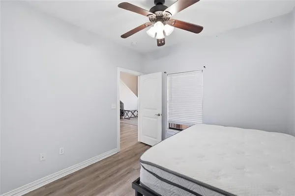 a bedroom with a bed and a chandelier fan