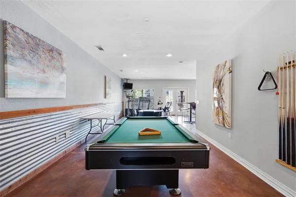a room with pool table and wooden floor