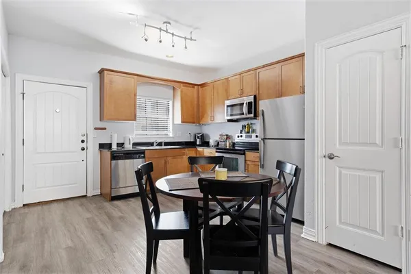 a kitchen with a refrigerator a stove a dining table and chairs