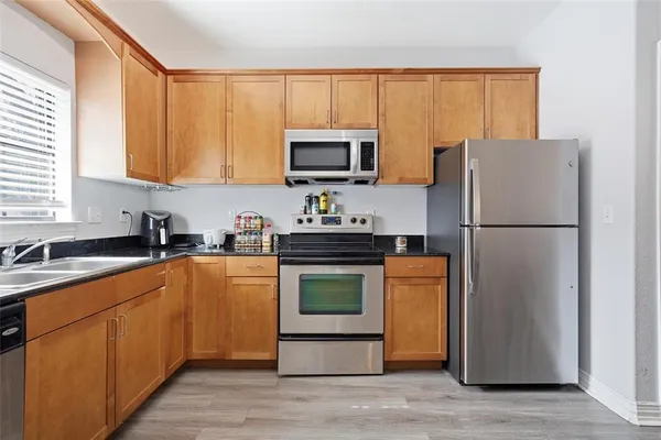 a kitchen with stainless steel appliances granite countertop a refrigerator stove a sink dishwasher and a refrigerator