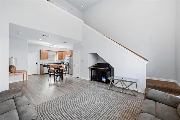 a living room with furniture and a dining table with kitchen view