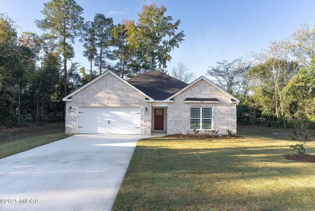 a view of a house with a yard and large tree