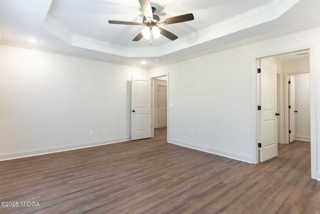 an empty room with wooden floor a ceiling fan and closet