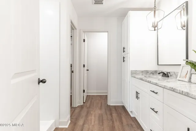 a bathroom with a granite countertop sink a mirror and a shower
