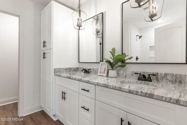 a bathroom with a granite countertop sink a mirror and a shower