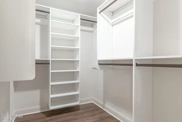 a view of walk in closet with empty racks