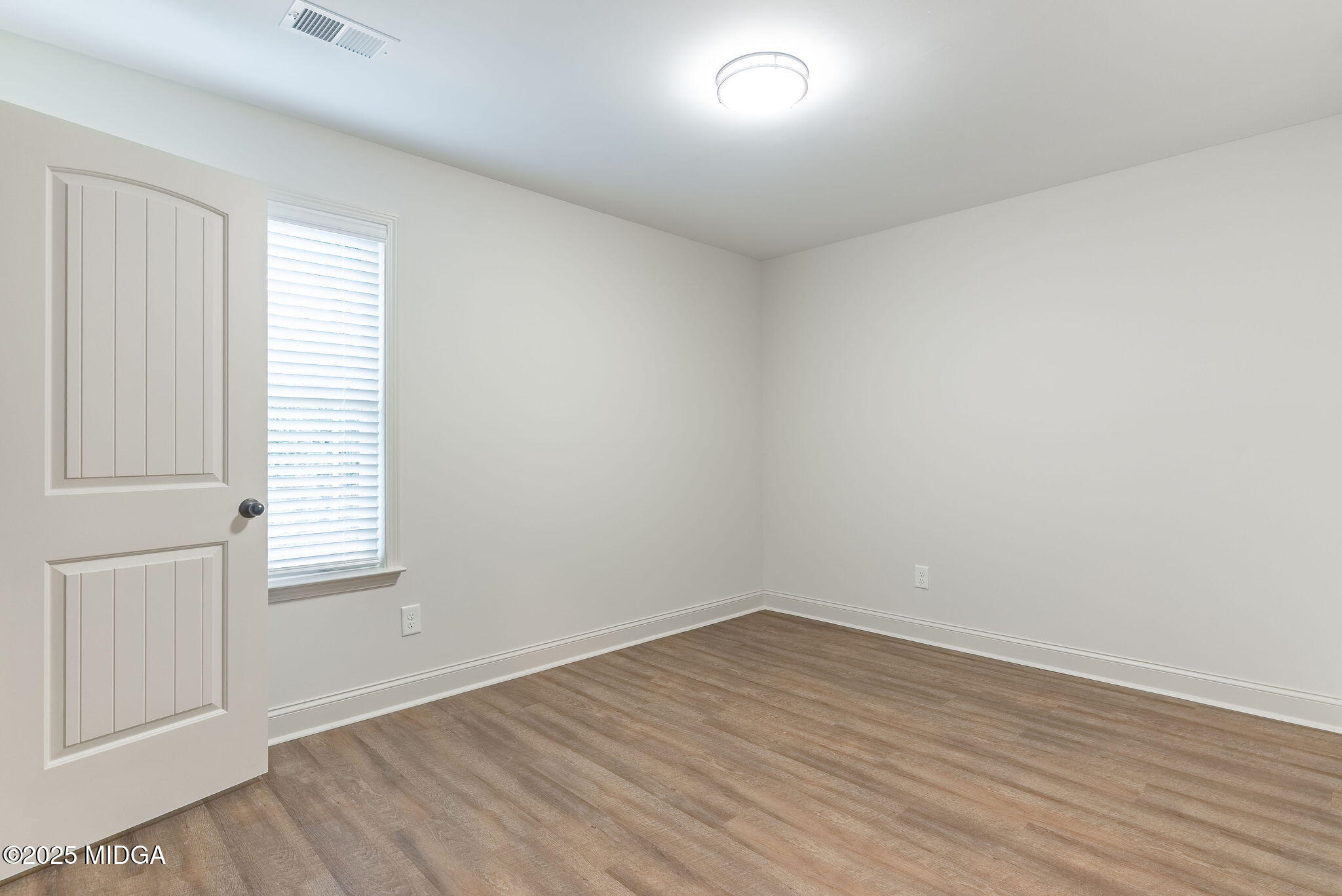 116 Fred Court Macon, GA 31216 - Photo 20 of 27 an empty room with wooden floor and windows