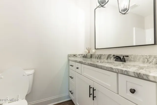 a bathroom with a granite countertop sink and a mirror