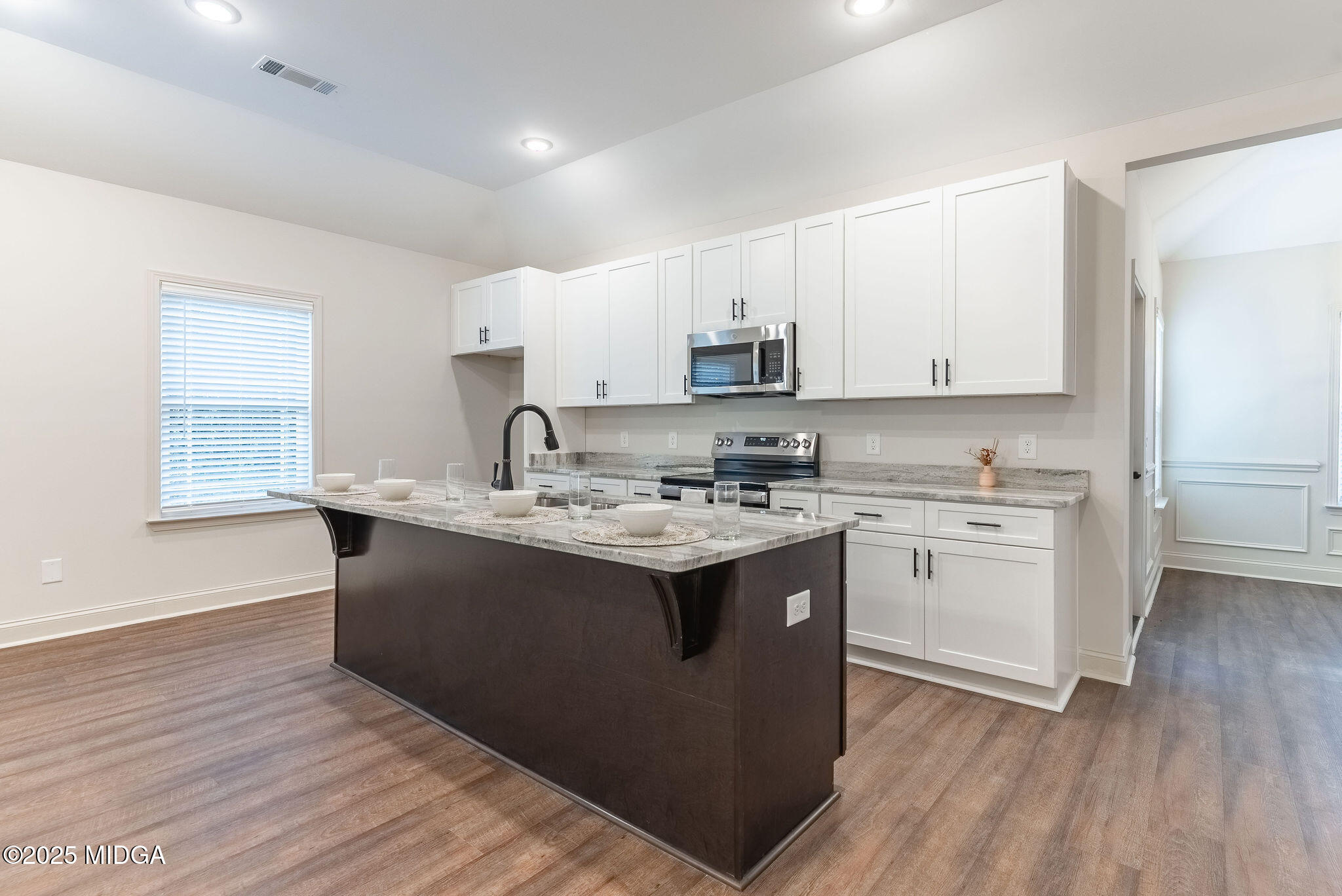 116 Fred Court Macon, GA 31216 - Photo 4 of 27 a kitchen with kitchen island granite countertop a sink appliances cabinets and a counter top space
