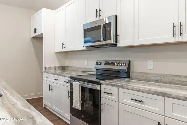 a kitchen with stainless steel appliances granite countertop white cabinets a sink and dishwasher