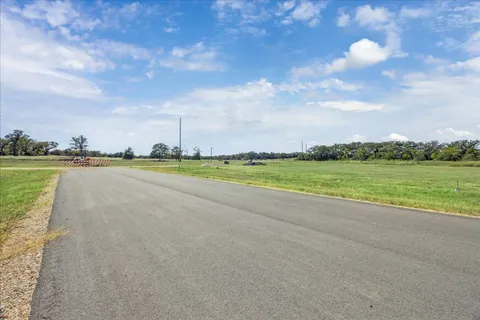 a view of a lake with a big yard and large trees