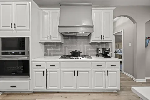 a kitchen with stainless steel appliances granite countertop a stove a microwave and cabinets