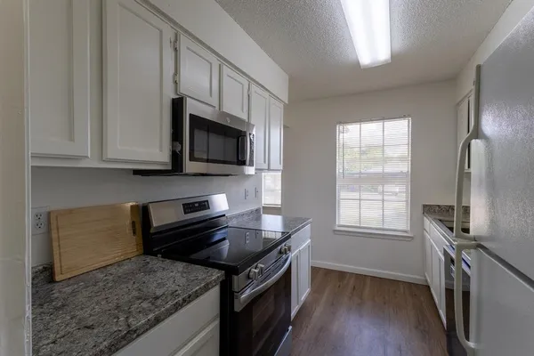 a kitchen with stainless steel appliances granite countertop a stove microwave and sink