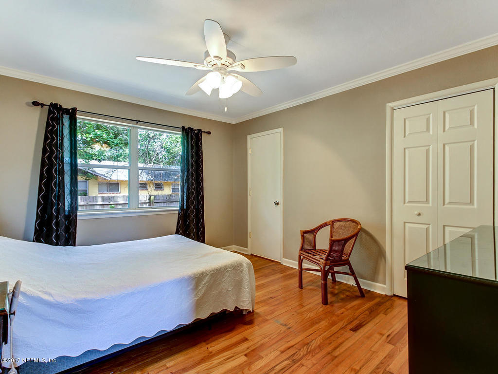 3754 Coronado Road Jacksonville, FL 32217 - Photo 10 of 19 a bedroom with a bed and a chandelier