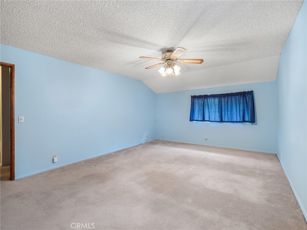 1725 Linnet Road Wrightwood, CA 92397 - Photo 25 of 43 an empty room with chandelier fan and windows