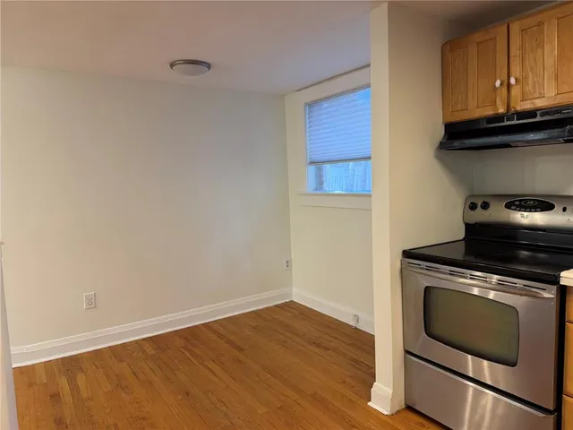 a kitchen with granite countertop wooden cabinets and a stove