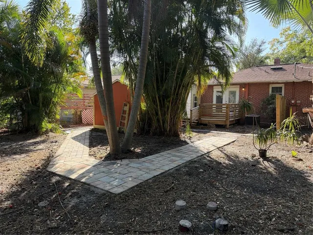 a view of a house with backyard and sitting area