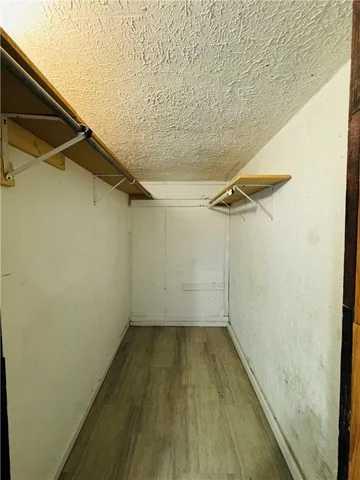a view of a room with wooden floor and small window