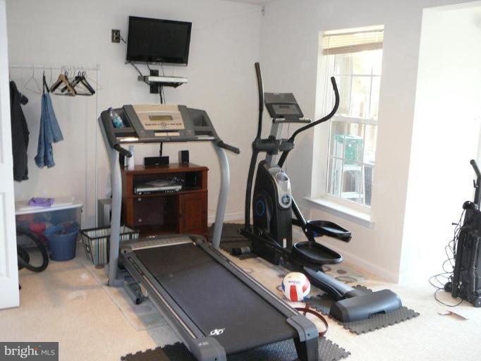 654 Wild Hunt Road Frederick, MD 21703 - Photo 3 of 17 a room with gym equipment and a flat screen tv