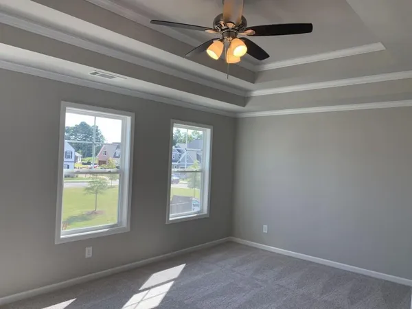an empty room with windows and fan