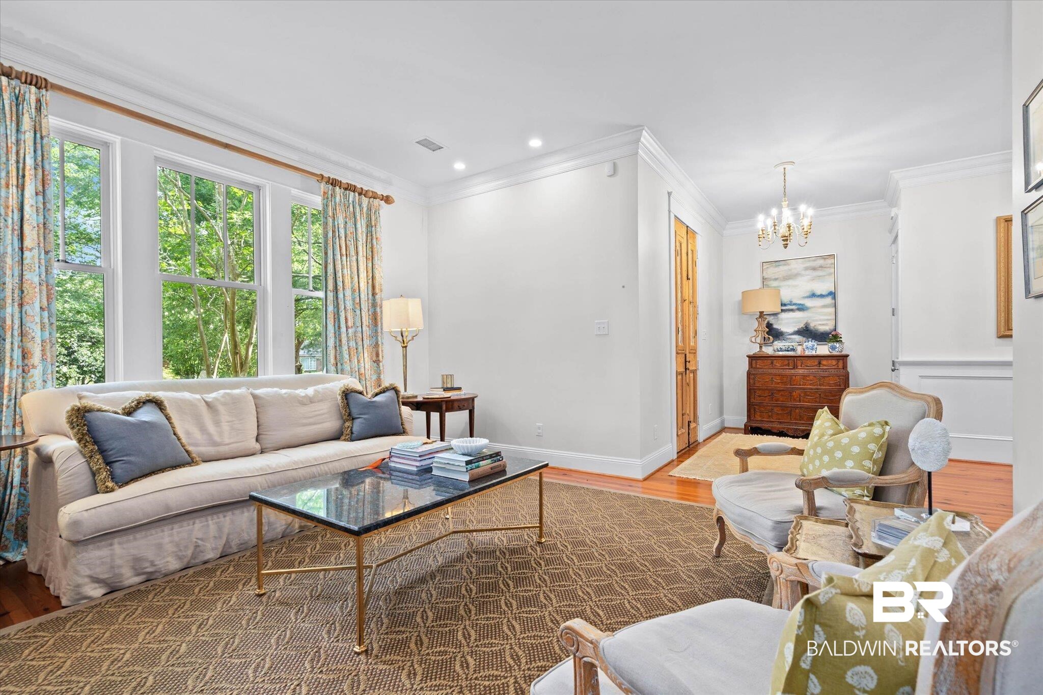 3813 Austill Lane Mobile, AL 36608 - Photo 2 of 37 Bright interior space featuring hardwood flooring, extensive white crown molding, recessed lighting, a triple window offering ample natural light, and a brass chandelier