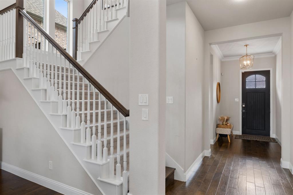 1806 Evening Star Road Frisco, TX 75033 - Photo 9 of 38 Entrance foyer featuring dark wood-type flooring, ornamental molding, and an inviting chandelier