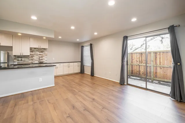 a view of kitchen with stainless steel appliances granite countertop white cabinets and wooden floor