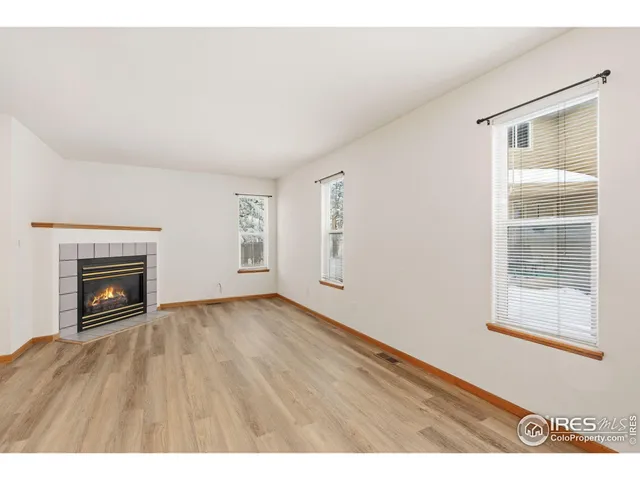 a view of an empty room with a fireplace and a window