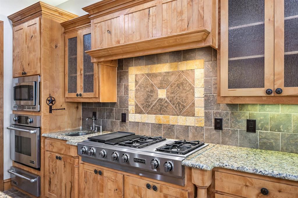 2085 Switzer Road Sanger, TX 76266 - Photo 10 of 39 Kitchen featuring light wood cabinetry, stainless steel appliances, granite countertops, a built-in gas range, and a tiled backsplash with decorative inlay