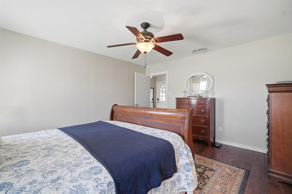 121 Sandy Lane Clyde, TX 79510 - Photo 18 of 30 a bedroom with a bed and wooden floor