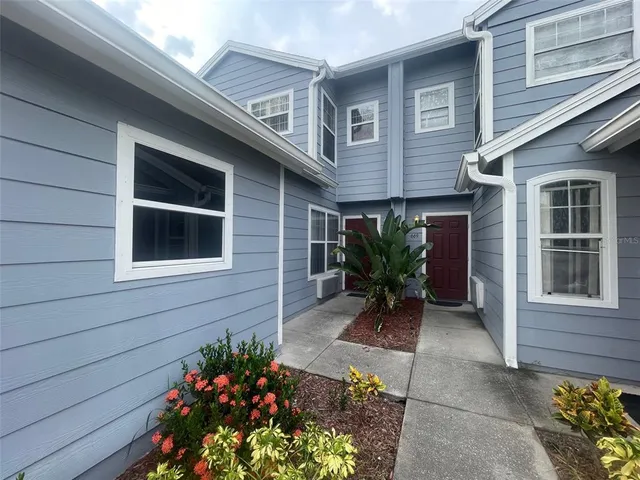 a front view of a house with a large window and potted plants