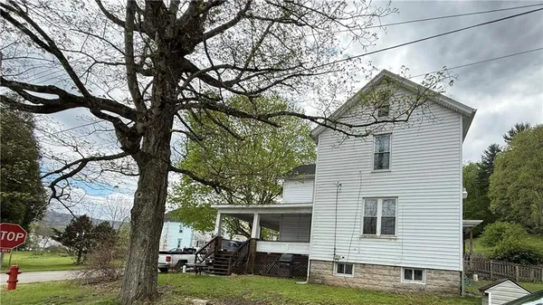 a view of a yard in front of a house with large tree