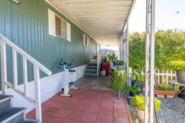 a view of a porch with furniture and garden