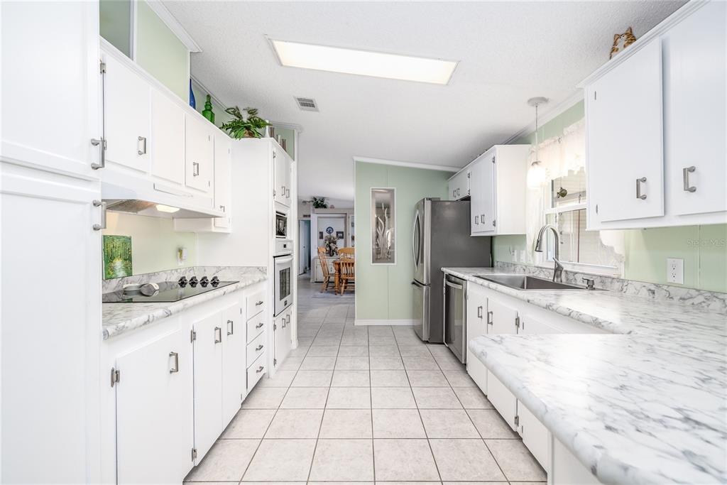 501 Topside Circle Edgewater, FL 32141 - Photo 13 of 47 a kitchen with stainless steel appliances a sink stove and cabinets
