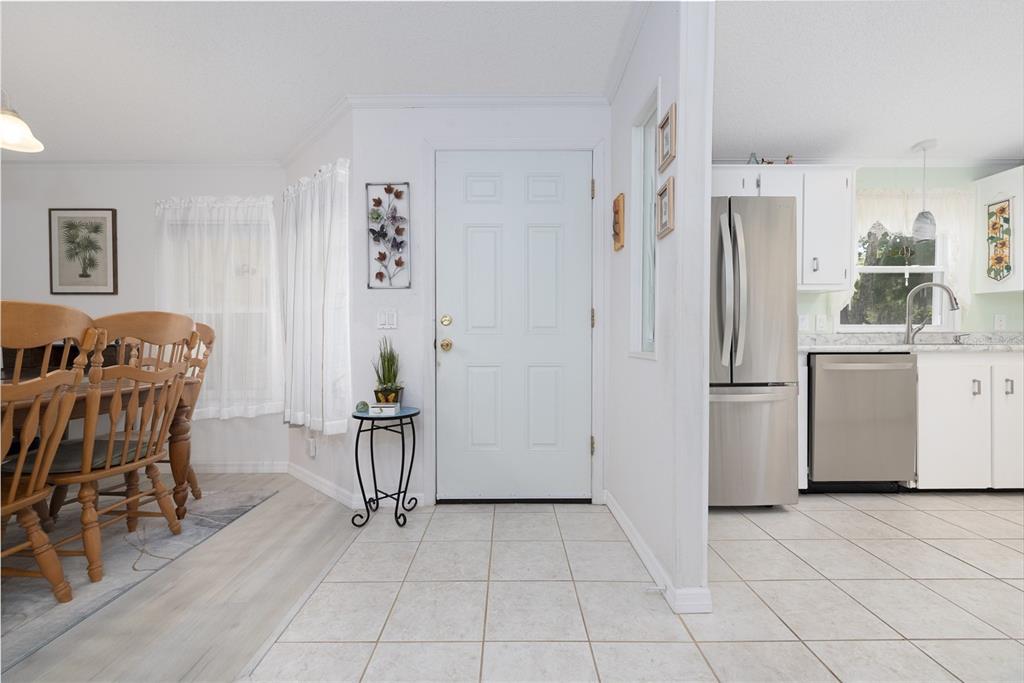 501 Topside Circle Edgewater, FL 32141 - Photo 10 of 47 a living room with furniture a dining table and a refrigerator