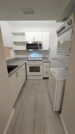 a kitchen with white cabinets and white appliances