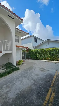 a view of a house with a yard and potted plants