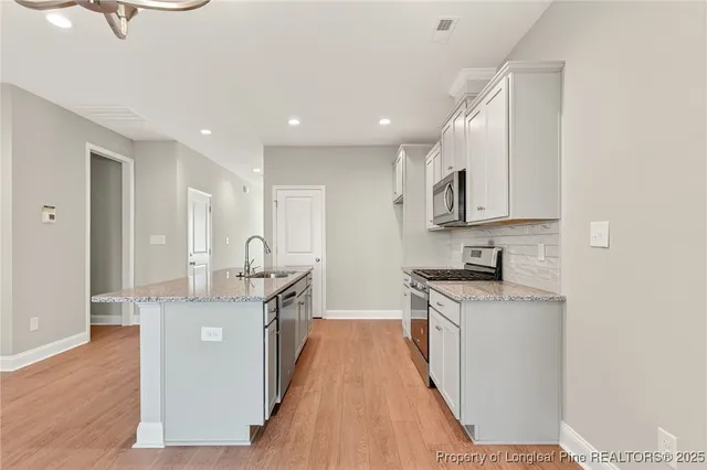 a kitchen with stainless steel appliances granite countertop a stove and a sink