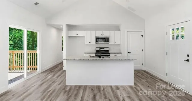 a kitchen with kitchen island a sink cabinets and wooden floor