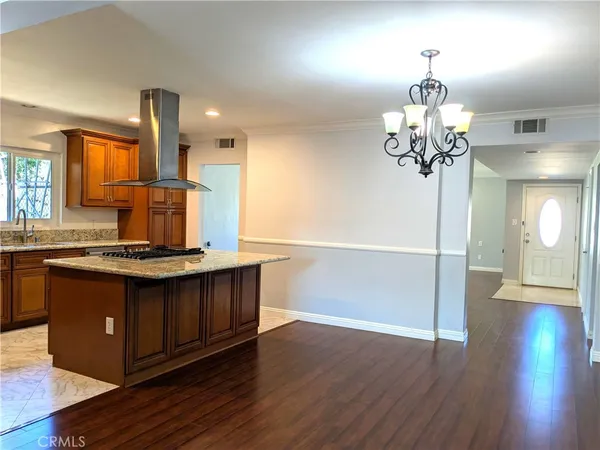 a kitchen with stainless steel appliances granite countertop a stove and a wooden floors