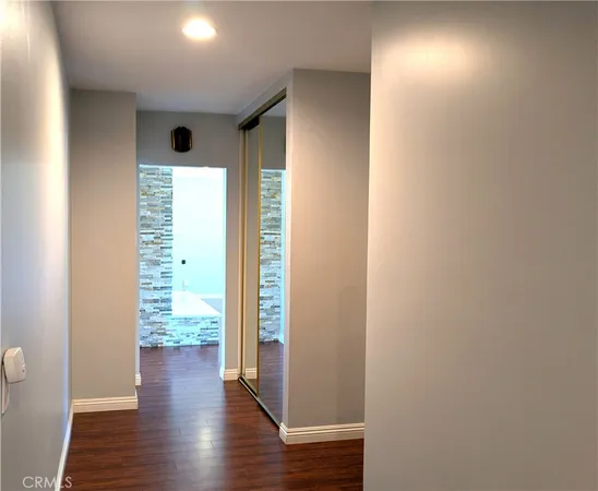 a view of a hallway with wooden floor and windows