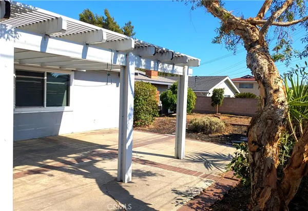 a view of a house with a tree and wooden fence