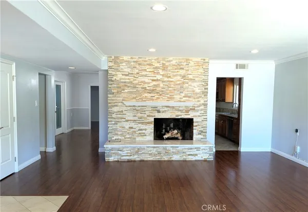 a view of a livingroom with wooden floor and a fireplace