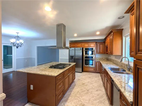 a kitchen with kitchen island granite countertop a sink counter top space and stainless steel appliances