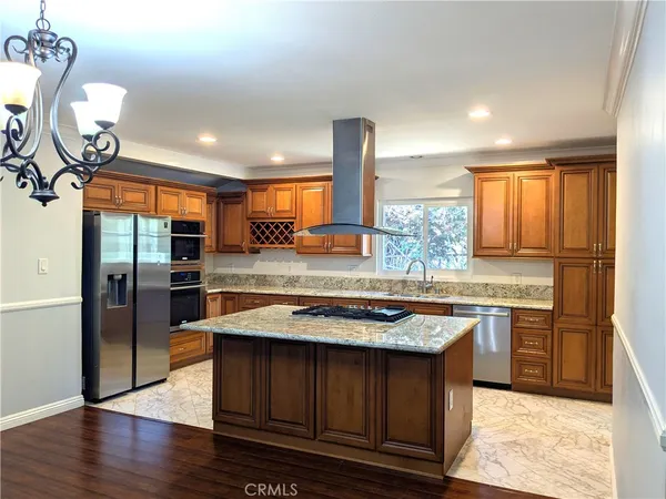 a kitchen with stainless steel appliances granite countertop wooden floors and sink
