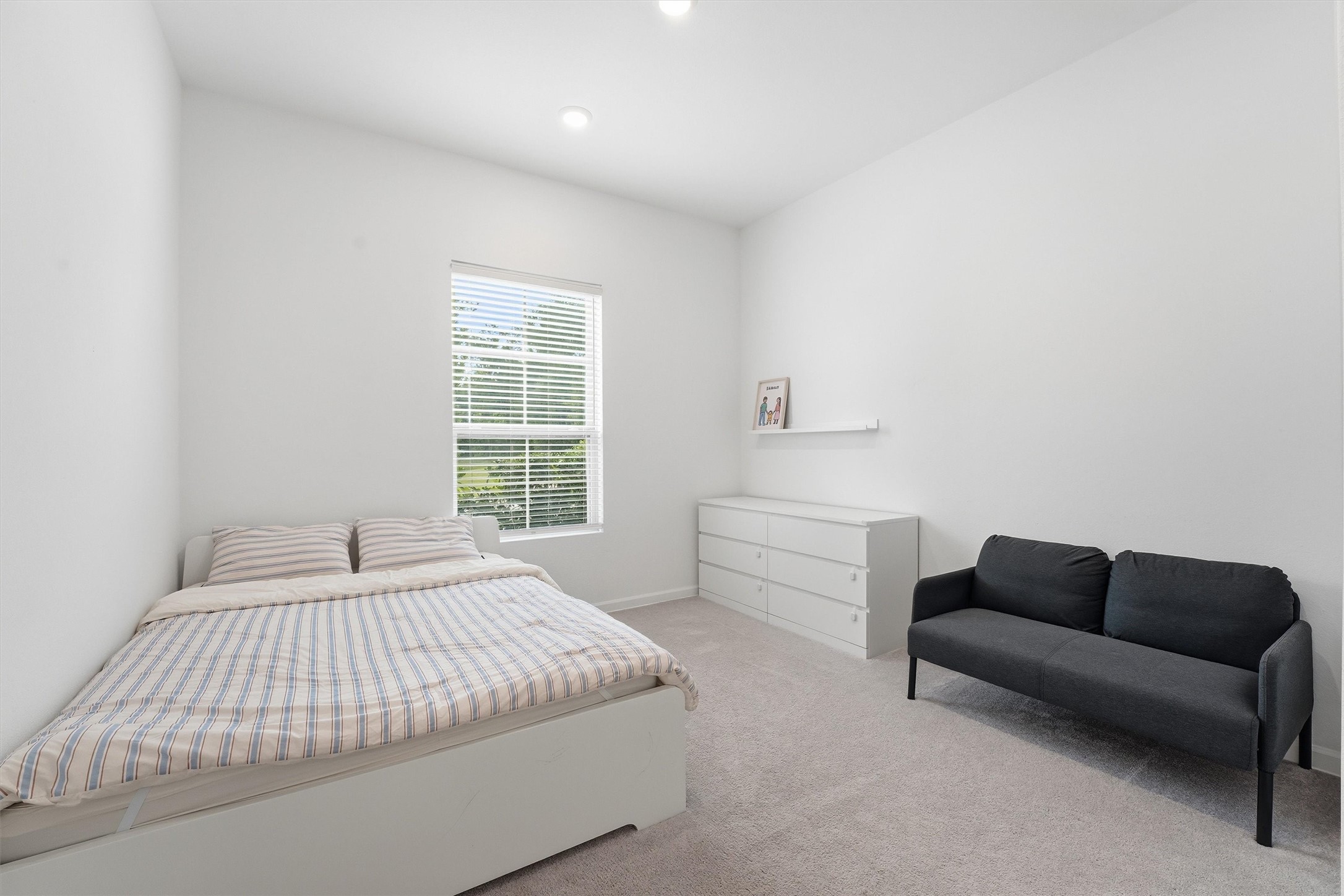 6071 Windward Falls Way Porter, TX 77365 - Photo 5 of 33 This bright bedroom features a plush carpet. Natural light pours in through a large window, creating a welcoming atmosphere.